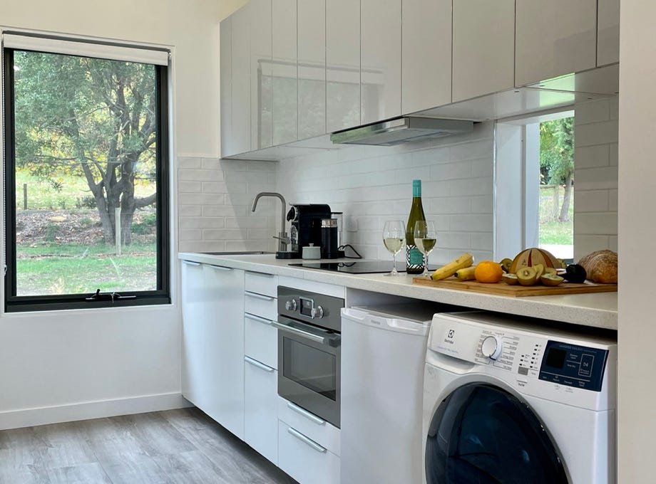 An open spacious modern functional kitchen, with washing machine